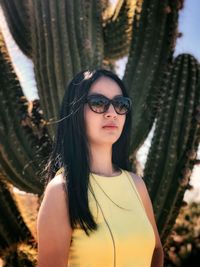 Portrait of young woman wearing sunglasses standing outdoors