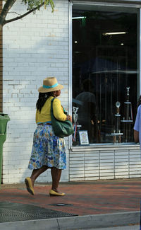 Rear view of woman walking on sidewalk