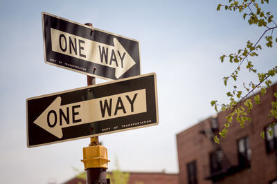 Low angle view of road sign against clear sky