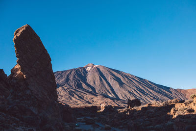 View of volcanic mountain against blue sky