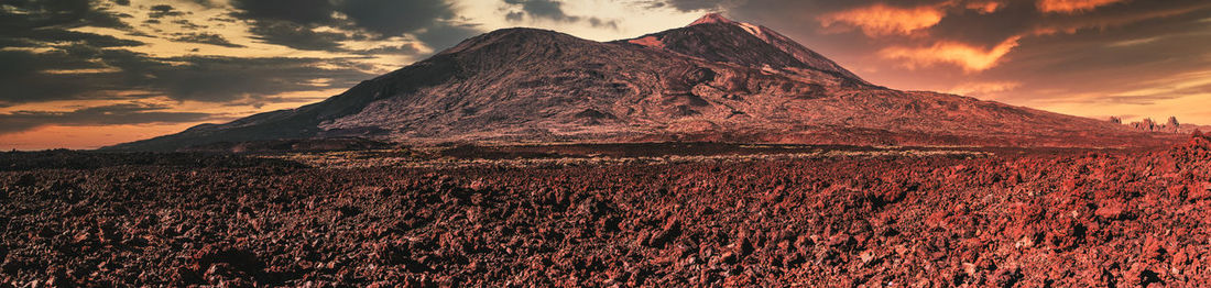 Scenic view of rock against sky during sunset