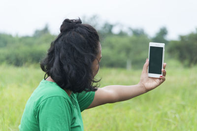 Rear view of woman photographing through camera