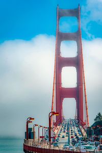 Low angle view of bridge over sea against cloudy sky