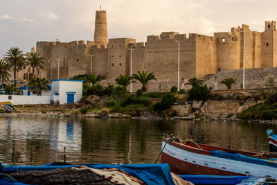 Boats moored in sea against buildings