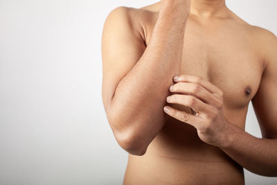 Young caucasian man suffering from forearm bone injury pain isolated on white background.