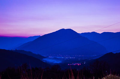 Scenic view of silhouette mountains against romantic sky at sunset