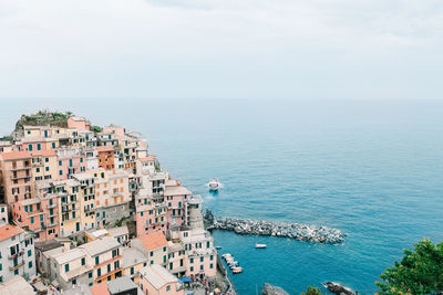 High angle view of townscape by sea against sky