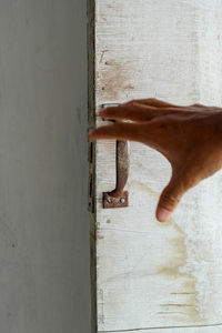 Cropped hand reaching towards door handle