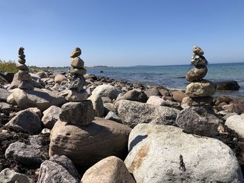 Stack of rocks on beach against clear sky