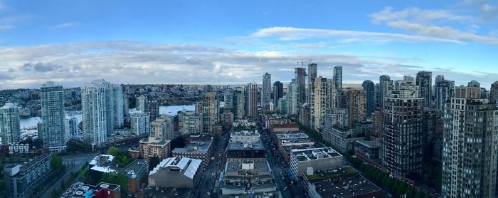 Aerial view of cityscape against cloudy sky