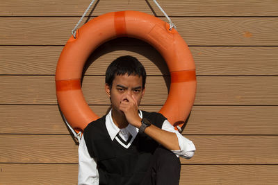 Portrait of young man sitting on hardwood floor