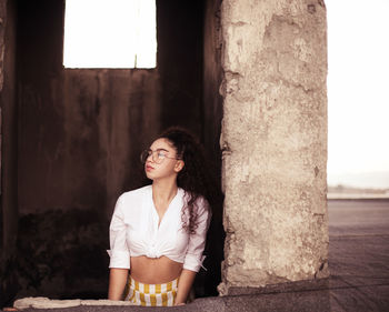 Young woman standing at old building