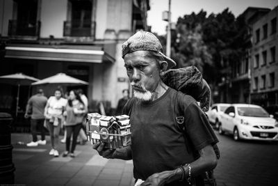 Man with umbrella on street in city