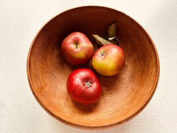 Three apples in  wooden bowl. red and green apples. foraged  in community orchard. fresh and juicy.