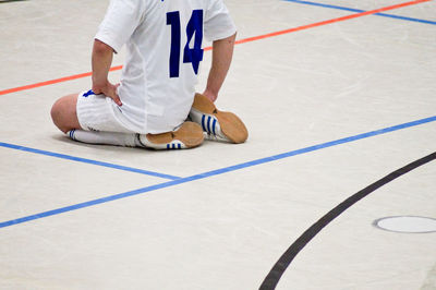 Low section of soccer player kneeling at court