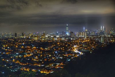 High angle view of illuminated buildings against sky at night