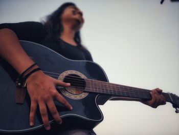 Full length of a woman playing guitar