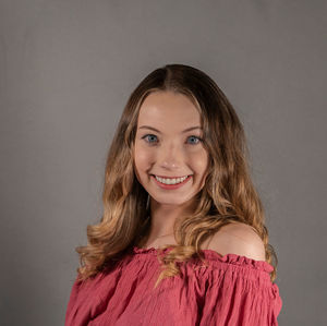 Portrait of a smiling young woman against gray background