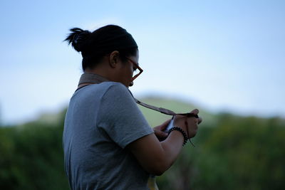 Side view of mature woman standing against sky