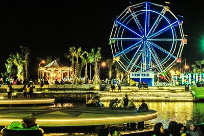 Illuminated ferris wheel at night