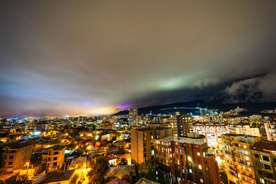 High angle view of illuminated cityscape against sky at night