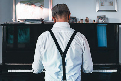 Rear view of a man standing at home