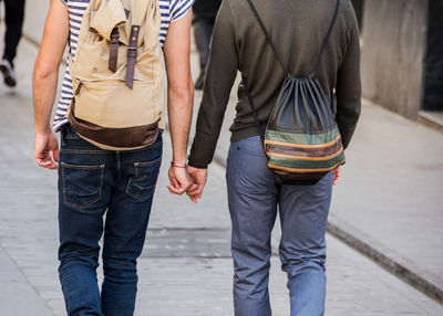Midsection of friends standing on street