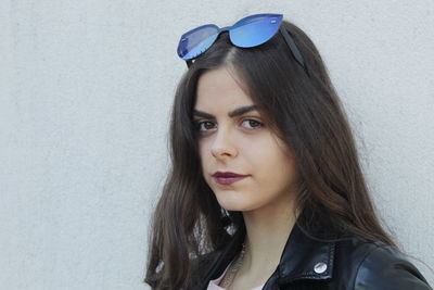 Portrait of beautiful woman against wall