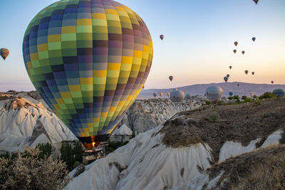 Hot air balloons flying over sea against sky