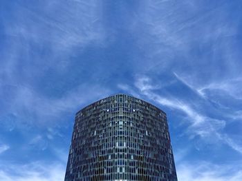 Low angle view of modern glass building against sky