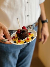 Midsection of woman holding cake