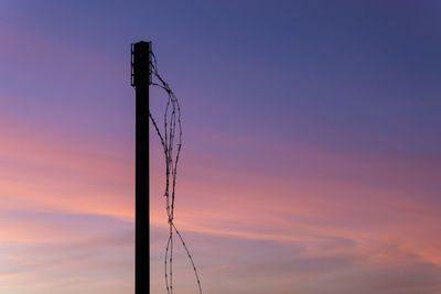 Silhouette pole against sky during sunset