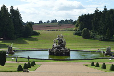 Scenic view of park by lake against sky