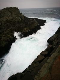 Scenic view of rocks in sea against sky