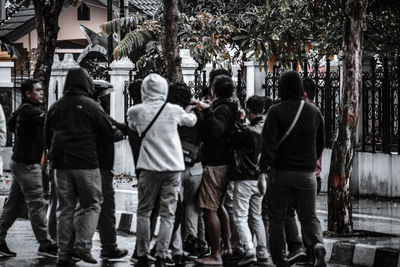 Rear view of people walking on street in city