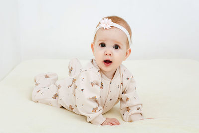 Portrait of cute baby boy lying on bed at home