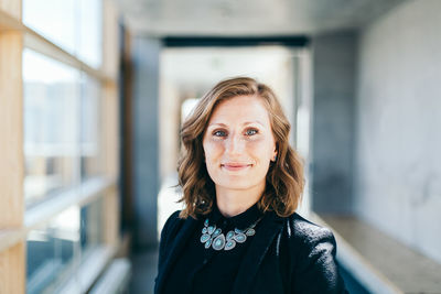 Portrait of woman standing against wall