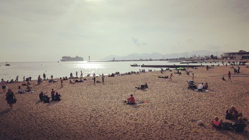 Group of people on beach against sky