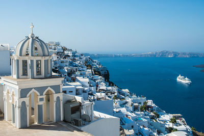 Panoramic view of sea and buildings against blue sky