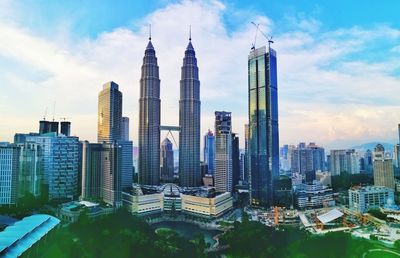 Panoramic view of skyscrapers against cloudy sky