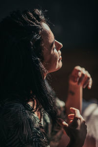 Close-up of woman holding hands at night