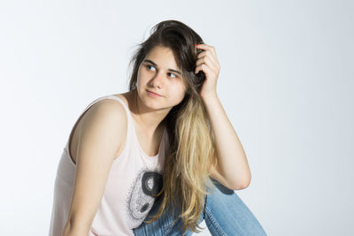 Portrait of beautiful young woman against white background