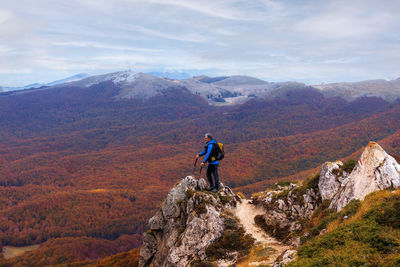 Rear view of man looking at mountain against sky