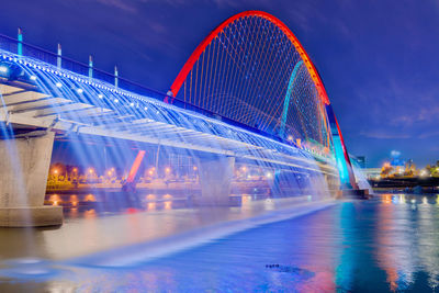 Illuminated modern bridge against sky at night