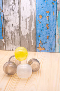 High angle view of plastic balls by glass on wooden floor