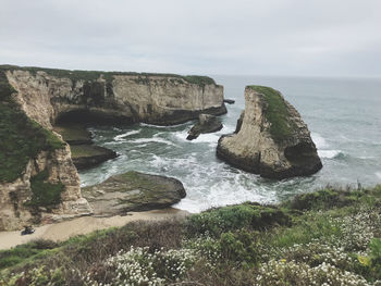 Rock formations by sea against sky