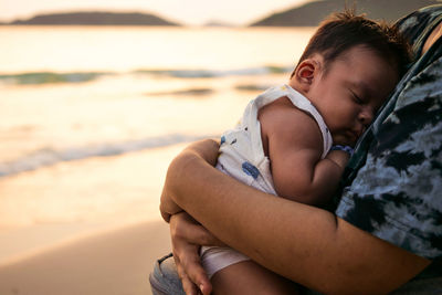 Midsection of boy sitting at beach