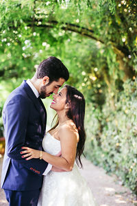 Couple embracing against trees