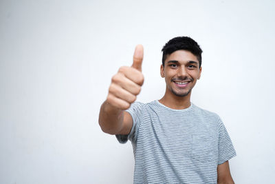 Portrait of smiling man standing against white background