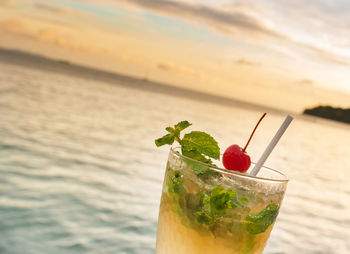 Close-up of drink on table against sea